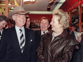 Former British Prime Minister Margaret Thatcher, wearing the traditional Australian oilskin raincoat. Drizabone, smiles at her husband Denis (L), wearing the stockman Akubra hat. 01 August 1988 in Perth on the first day of their visit to Australia. Sir Denis Thatcher died 26 June 2003 at London hospital. He was 88. AFP PHOTO PATRICK RIVIERE.