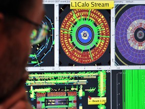 A file photo taken on September 10, 2008, shows a scientist looking at results from the Large Hadron Collider. CERN, the organization that governs the collider said on Thursday that a loose cable may have been behind results that showed particles moving faster than light.