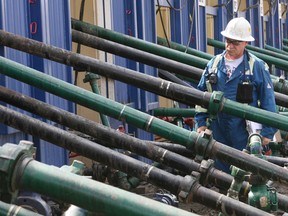 Gord Boswer inspects the fracking pipes leading into the well heads at a facility in British Columbia.