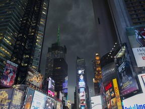 Storm clouds loom over Times Square as Manhattan braced for heavy weather, Thursday, July 26, 2012, in New York. The storm resulted in more than 20,000 customers without power in the Elmira area in upstate New York, where buildings were damaged, power lines and trees toppled, and hospitals placed on disaster status after a possible tornado hit the city Thursday afternoon. (AP Photo/John Minchillo)