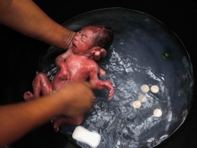 A newborn baby is washed at a temporary shelter in the Philippines. But we want to see it come out!
