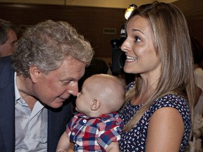 Quebec Liberal Party Leader Jean Charest, left, meets six-month-old Arthur St-Amand while his mother Genevieve Villemure Denis holds him at a rally Saturday, August 4, 2012 Quebec City. Quebecers will be voting in a general election on Sept. 4. THE CANADIAN PRESS/Jacques Boissinot