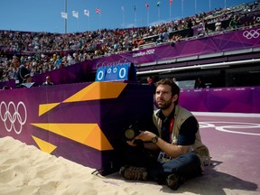 National Post photographer Tyler Anderson sits in the best seat in the stadium on the edge of the beach volleyball court as the Candians take on Italy at the London 2012 Olympic Games in London, England, August 2, 2012.
