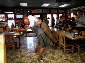 President Obama is lifted in the air by Scott Van Duzer, owner of the  Big Apple Pizza