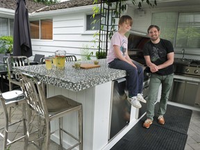 Chef Dale MacKay and son Ayden pose in an inspiring outdoor kitchen. Get cooking.