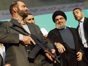 Lebanon's Hezbollah leader Sayyed Hassan Nasrallah (2nd R), escorted by his bodyguards, greets his supporters at an anti-U.S. protest in Beirut's southern suburbs September 17, 2012.