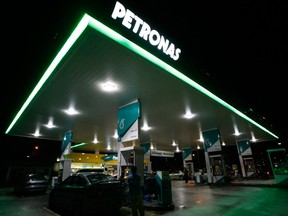 Motorists pump petrol at a Petronas station in Putrajaya in this December 8, 2009 file photograph.The Canadian government blocked the C$5.17 billion (3.2 billion pounds) acquisition of Progress Energy Resources Corp by Malaysian state oil company Petronas, raising questions about other, bigger bids and about Canada's willingness to let foreign investors in.