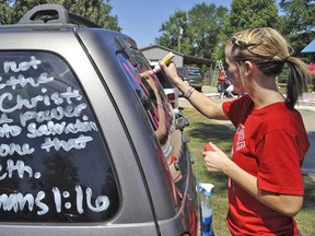 Local Input~ Kountze High School cheerleader Brooke Coates paints scripture verses on a car Wednesday, Sept. 19, 2012 in Kountze, Texas.  The small Hardin County community is rallying behind the high school's cheerleaders after the squad members were told they could not use scripture verses on their signs at the football games. (AP Photo/The Beaumont Enterprise, Dave Ryan)