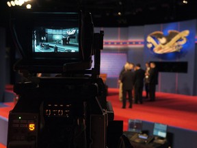 Last minute stage setup for the first Presidential Debate between President Barack Obama and Republican presidential nominee Mitt Romney at the University of Denver take place as seen in a television camera monitor Wednesday, Oct. 3, 2012, in Denver. (AP Photo/J. David Ake)