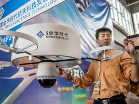 A man adjusts the display of a Chinese-made drone equipped with a surveillance camera during the 9th China International Aviation and Aerospace Exhibition in Zhuhai.