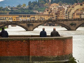 People look at the level of the river Arno on November 13, 2012 in Florence. The heavy rains left four victims in Tuscany with three of them found in a car.