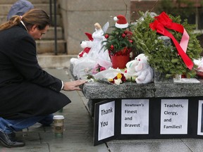 A couple pause at a memorial outside town hall in Newtown, Conn., Monday, Dec. 17, 2012. A gunman opened fire at Sandy Hook Elementary School in the town, killing 26 people, including 20 children before killing himself on Friday. (AP Photo/Charles Krupa)