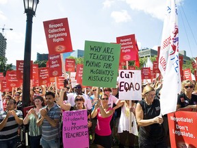 Protesters show their support at a rally for public education and democracy organized by The Elementary Teachers' Federation of Ontario to protest the Ontario government's legislation that teachers say will tear up their collective agreements at Queens Park in Toronto on Tuesday August 28, 2012. (Aaron Vincent Elkaim / Canadian Press files)