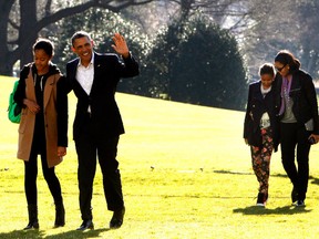U.S. President Barack Obama walks with daughter Malia, while first lady Michelle Obama walks with daughter Sasha from Marine One to the White House