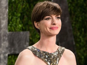 Anne Hathaway carrying her Oscar for best supporting actress arrives for the 2013 Vanity Fair Oscar Party on February 24, 2013 in Hollywood, California.   AFP PHOTO / ADRIAN SANCHEZ-GONZALEZADRIAN SANCHEZ-GONZALEZ/AFP/Getty Images