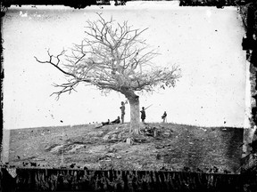 Soldiers stand next to a lone grave after the Battle of Antietam near Sharpsburg, Md., in 1862, the bloodiest one-day battle in American history