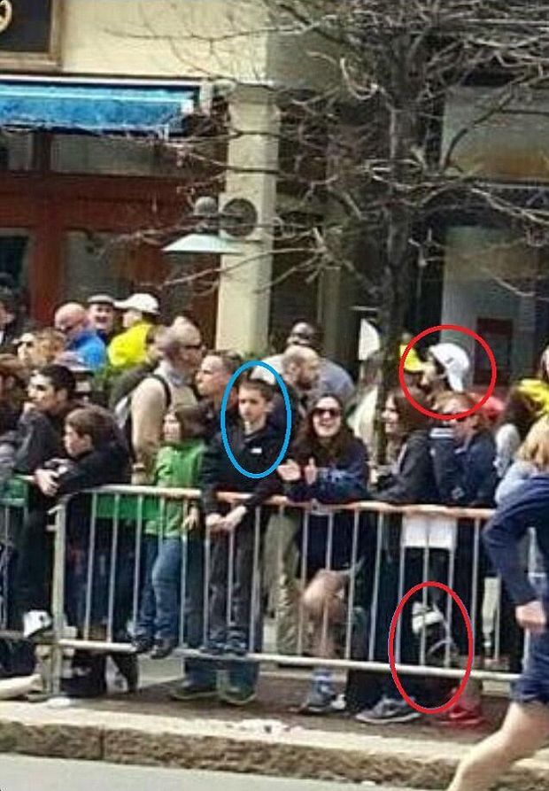 This photo, believed to be from social media and posted on The Daily Mail's website, shows one of the Boston Marathon bombing suspects (Suspect #2 - white hat, Dzhokhar Tsarnaev) standing right behind eight-year-old victim Martin Richard (ringed, left) moments before the explosion on Monday, April 15, 2013.   