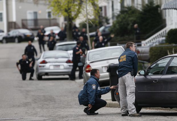 Police officers surround a home during a search for a suspect in the Boston Marathon blasts in Watertown, Mass.
