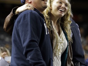 Two fans embrace while singing "Sweet Caroline" as a tribute to the victims of the Boston Marathon explosions after the third inning of a baseball game between the New York Yankees and the Arizona Diamondbacks at Yankee Stadium in New York, Tuesday, April 16, 2013. The song by Neil Diamond has been a longtime fixture as a fan sing-along during the bottom of the eighth inning of Boston Red Sox games. In big ways and small, New York is putting aside its heated and historical rivalry with Boston in a show of support after the Boston Marathon explosions. (AP Photo/Kathy Willens)