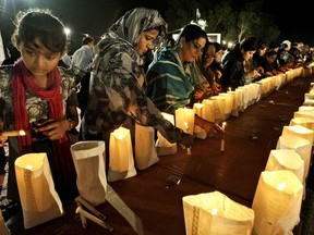 Pakistani workers of political party Muttahida Qaumi Movement 'MQM', light candles during a protest to condemn the killing of foreign tourists by militants, in Karachi, Pakistan, Sunday, June 23, 2013. Islamic militants wearing police uniforms shot to death many foreign tourists and one Pakistani before dawn as they were visiting one of the world's highest mountains in a remote area of northern Pakistan that has been largely peaceful, officials said. (AP Photo/Fareed Khan)