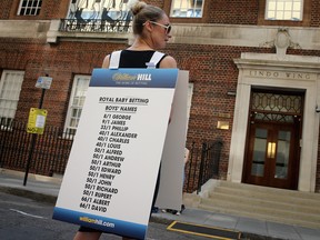 A girl from a Betting Company wears a board highlighting the latest odds on babies names outside the Lindo wing of St Mary's Hospital before the baby was born.