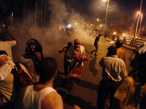 TOPSHOTS People run for cover as security forces fire tear gas after shooting to disperse Islamist supporters of ousted president Mohamed Morsi outside the Republican Guard headquarters in Cairo in the early hours of July 8, 2013. Sixteen Islamist activists were shot dead during a protest outside the key Cairo army headquarters calling for Morsi to be reinstated, according to his Muslim Brotherhood group. AFP PHOTO/MAHMOUD KHALEDMAHMOUD KHALED/AFP/Getty Images