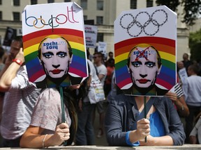Activists holding placards depicting Russian President Vladimir Putin, participate at a protest against Russia's new law on gays, in central London.