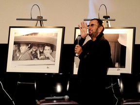 Ringo Starr gestures to an image of a group of fans he photographed in Miami in 1964.