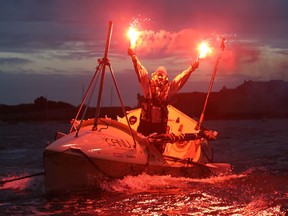 Quebec rower Mylene Paquette celebrates as she arrives in Lorient, western France, Tuesday, Nov. 12, 2013, after a solo journey across the Atlantic Ocean. Paquette is the first North American woman to row solo across the North Atlantic. She left Halifax just over four months ago in a specially designed 7.3-metre boat propelled only by Paquette and the currents. (AP Photo/David Vincent)