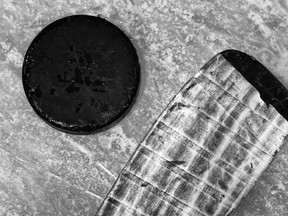hockey stick and puck on ice rink