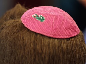 An alligator adorns a yarmulke on a guest's head as he takes part in a community Passover Seder in Miami Beach, Fla.