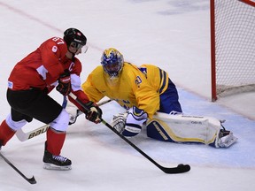 Canada's Sidney Crosby (left) scores on Swedish goaltender Henrik Lundqvist in the Olympic men's hockey final in Sochi on Feb. 23, 2014.