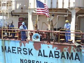 FILE - In this Nov. 22, 2009 file photo, crew members work aboard the U.S.-flagged Maersk Alabama after the ship docked in the harbour of Mombasa, in Kenya. Police in the Indian Ocean island nation of Seychelles said Wednesday, Feb. 19, 2014 that two American security officers were found dead Tuesday in a cabin on the Maersk Alabama, the ship hijacked by pirates in 2009, an event dramatized in the movie "Captain Phillips" starring Tom Hanks. (AP Photo, File)