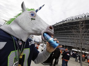 Kellan Smalley, in a unicorn head, from Bremerton Wash., drinks a beer outside MetLife Stadium before the NFL Super Bowl XLVIII football game between the Seattle Seahawks and the Denver Broncos, Sunday, Feb. 2, 2014, in East Rutherford, N.J. (AP Photo/Seth Wenig)
