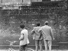 This file picture taken on August 26, 1961 shows men on the western side of the Berlin Wall talk to their girlfriends behind a fence at the train station Stettiner Bahnhof in Berlin, Germany. On the morning of August 13, 1961, East Berliners woke to find soldiers had blocked off the streets, cut off rail links and begun building a wall of barbed wire and cemented paving stones which over the years, in Berlin, grew in height and complexity over 155 kilometres (96 miles).  AFP PHOTO / DPA/ GÜNTER BRATKE     GERMANY OUTGÜNTER BRATKE/AFP/Getty Images ORG XMIT: POS1308130717450410