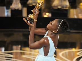 Actress Lupita Nyong'o accepts her Oscar for best supporting actress for 12 Years a Slave.