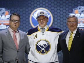 Sam Reinhart stands with Buffalo Sabres officials after being chosen second overall during the first round of the NHL hockey draft, Friday, June 27, 2014, in Philadelphia. (AP Photo/Matt Slocum)
