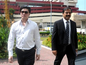 Singapore businessman Ding Si Yang, left, arrives with his lawyer at the state court for sentencing in Singapore on July 24, 2014. Ding was convicted of corruption for offering the services of prostitutes to three Lebanese referees in exchange for fixing football matches.