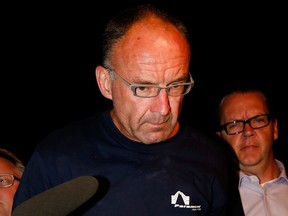 Douglas Garland is escorted into a Calgary police processing unit, July 14, 2014.