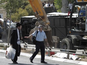 An Israeli policeman stands guard at the scene after a Palestinian man rammed an excavator into a Jerusalem bus, on August 4, 2014 in Jerusalem.