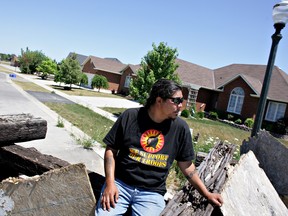 A native protestor sits on the barricade that separates the disputed Douglas Creek Estates land from a suburb of Caledonia in June 2007.