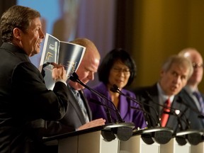 John Tory holds up a copy of his Smart Track transit plan as Rob Ford, Olivia Chow and David Soknacki watch during a mayoral debate at the Hilton Hotel in Toronto, Sept. 4, 2014.