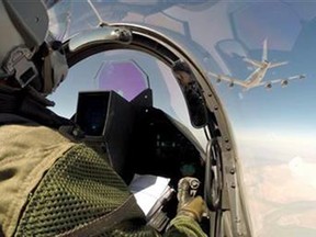 A remote camera shows a Rafale jet fighter, partially seen at right, and a pilot fly over Iraq Friday.