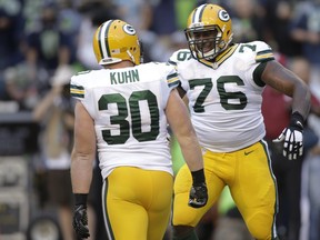 Green Bay Packers fullback John Kuhn (30) celebrates his touchdown against the Seattle Seahawks with Mike Daniels (76) in the first half of an NFL football game, Thursday, Sept. 4, 2014, in Seattle. (AP Photo/Stephen Brashear)