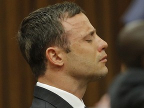 Oscar Pistorius reacts in the dock in Pretoria, South Africa, Thursday Sept. 11, 2014 as Judge Thokozile Masipa reads notes as she delivers her verdict in Pistorius' murder trial. The South African judge in Oscar Pistoriusí murder trial said Thursday that prosecutors have not proved beyond a reasonable doubt that the double-amputee Olympic athlete is guilty of premeditated murder. (AP Photo/Kim Ludbrook, Pool)