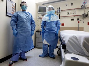 Bellevue Hospital nurse Belkys Fortune, left, and Teressa Celia, Associate Director of Infection Prevention and Control, pose in protective suits in an isolation room, in the Emergency Room of the hospital, during a demonstration of procedures for possible Ebola patients, Wednesday, Oct. 8, 2014. The U.S. government plans to begin taking the temperatures of travelers from West Africa arriving at five U.S. airports, including the New York area&#039;s JFK International and Newark Liberty International, as part of a stepped-up response to the Ebola epidemic.