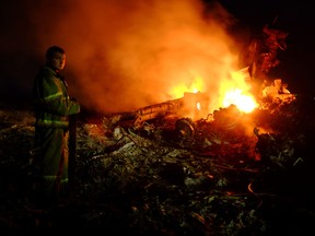 A firefighter stands  amongst the wreckage of Malaysian Airlines MH17 after it crashed, near the town of Shaktarsk, in rebel-held east Ukraine, on July 17, 2014.