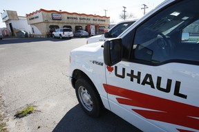 Vehicles are parked in front of a U-Haul store waiting for DIY movers.
