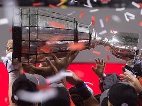 The top of Grey Cup trophy comes loose as the Calgary Stampeders hoist it after defeating the Hamilton Tiger-Cats to win the CFL championship game in Vancouver, B.C., on Sunday November 30, 2014. THE CANADIAN PRESS/Darryl Dyck