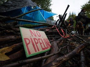 A camp setup by protesters is marked with a sign and tree branches at the entrance to a trail on Burnaby Mountain where work is being done by Kinder Morgan in preparation for the Trans Mountain Pipeline expansion project in Burnaby, B.C.